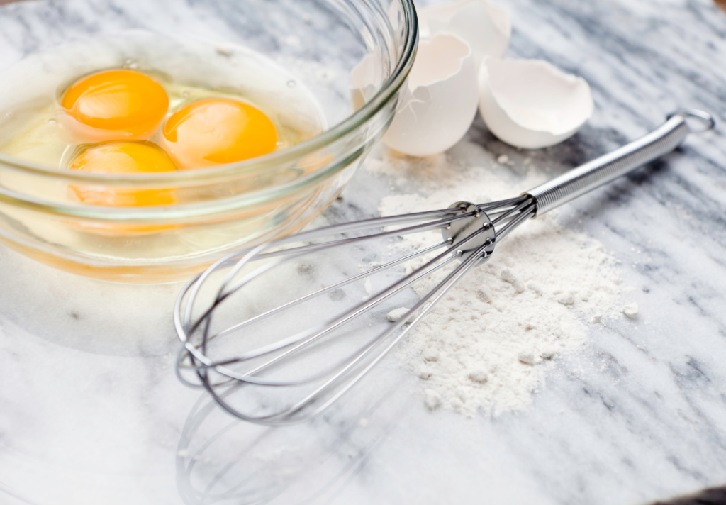 bowl of raw eggs and whisk